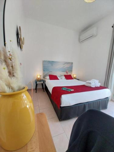 - une chambre avec un lit et un vase jaune dans l'établissement Hôtel Padolo, à Bonifacio