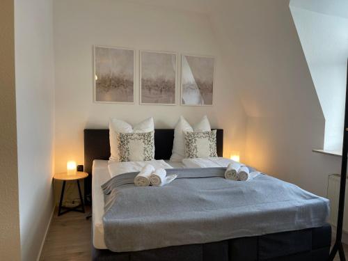 1 dormitorio con 1 cama con toallas en RAHA Apartments - Modernes Studio-Apartment - am HBF - kostenloser Parkplatz, en Erfurt