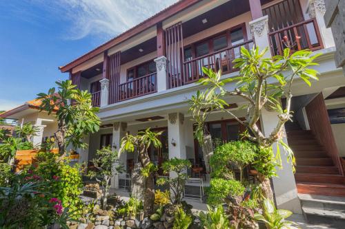 an exterior view of a house with trees and plants at Donahome in Sanur