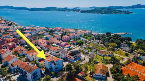 eine Luftansicht einer Stadt mit gelbem Pfeil in der Unterkunft Apartments Lovrić in Vodice