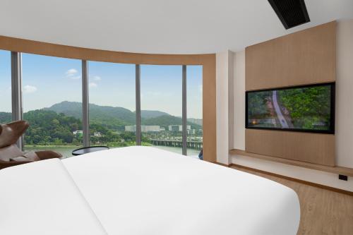 een slaapkamer met een groot bed en een flatscreen-tv bij Fairfield by Marriott Changsha Yuelu in Changsha