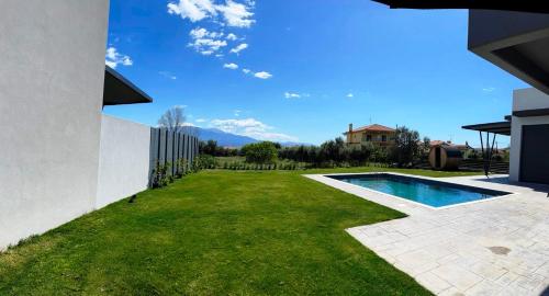 a backyard with a swimming pool and green grass at Nostos Luxury Villas with Private Pool in Nafpaktos in Nafpaktos