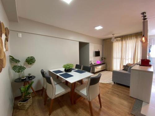 uma sala de estar com uma mesa e cadeiras e um sofá em Apartamento em localização privilegiada em Cuiabá