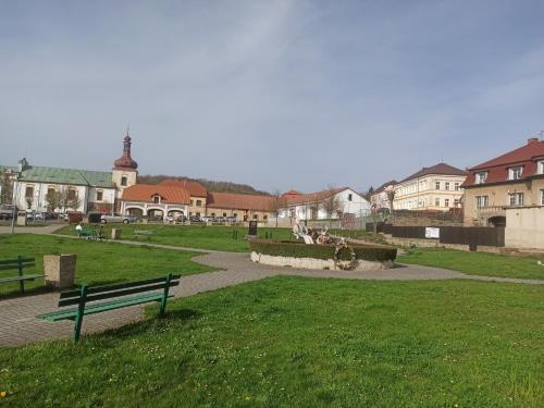 ein Park mit einer Bank und Gebäuden im Hintergrund in der Unterkunft Apartmán Kostomlaty pod Milešovkou in Kostomlaty pod Milešovkou