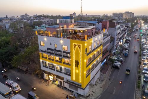 een geel gebouw in een stadsstraat bij zonsondergang bij The Hosteller Jaipur, MI Road in Jaipur