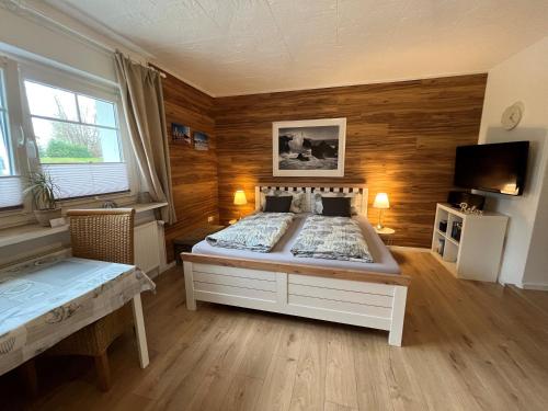 een slaapkamer met een groot bed en houten wanden bij Appartement 1 mit Küche und neuem Bad, frisch saniert in Friedrichskoog