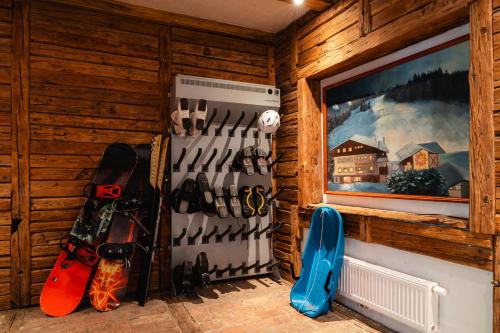 a room with a wall with snowboards and a tv at Hotel Sonnenalm Stuhleck in Spital am Semmering