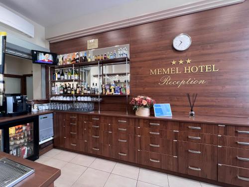 a bar in a hotel with a clock on the wall at Memel Hotel in Klaipėda