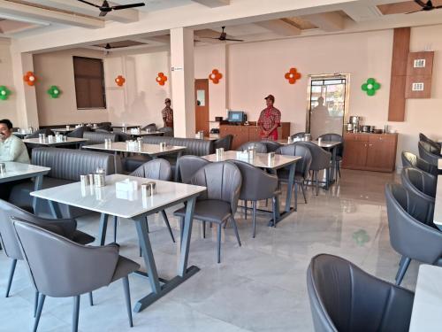 un restaurante con mesas y sillas y personas de pie en la habitación en Hotel The Marion, en Nashik