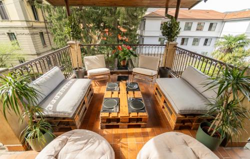 Un patio con sofás y una mesa de centro en un balcón. en Casa Anzi, en Como