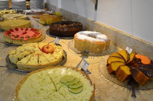 un montón de pasteles sentados sobre una mesa en Sky Premium Hotel Gramado - Ótima Localização, en Gramado