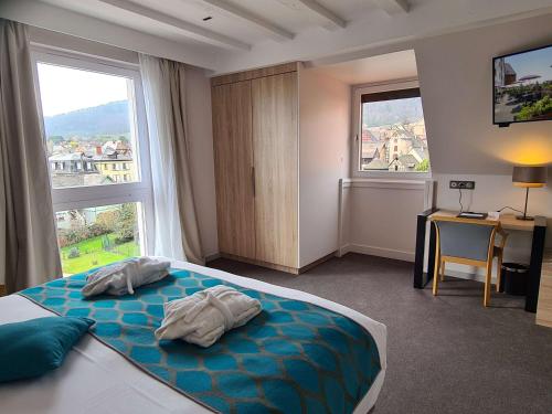 una camera da letto con un letto e due asciugamani di Best Western Hotel & SPA Le Schoenenbourg - Riquewihr - Proche Colmar a Riquewihr