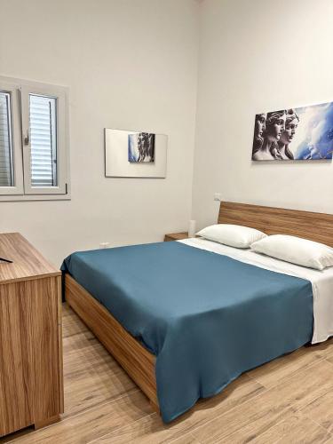 a bedroom with a large blue bed in a room at Athena Apartments Levante in Porto Cesareo