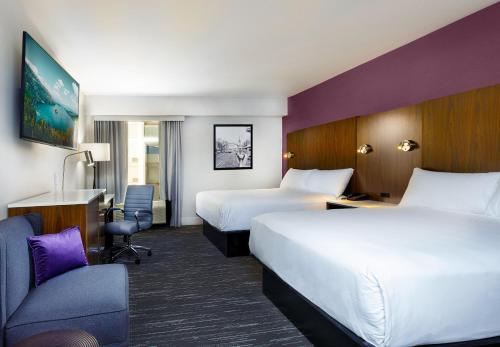 een hotelkamer met 2 bedden en een stoel bij J Resort in Reno