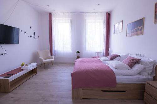 una camera da letto con un grande letto con una coperta rosa di Wagner Villa 902 with free private parking a Budapest