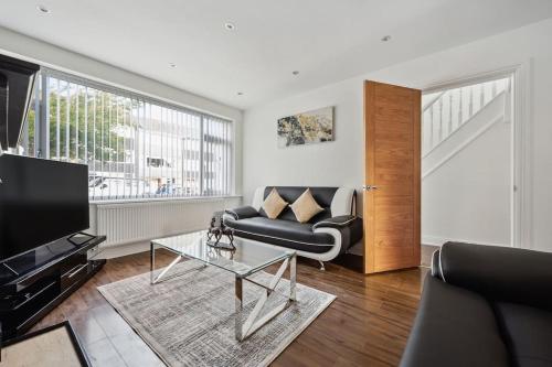 uma sala de estar com um sofá e uma mesa de vidro em house in Heald Green village em Manchester