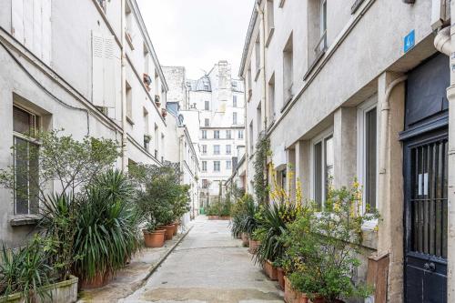 um beco com vasos de plantas e edifícios em ParisMyHome - AIR COND, 2 SHOWERS, 2 WC em Paris