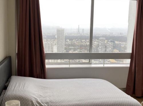 Tempat tidur dalam kamar di Apartment Paris La Défense Eiffel tower outlook