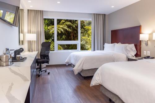 Cette chambre comprend deux lits et un bureau. dans l'établissement Hotel Biltmore, à Guatemala