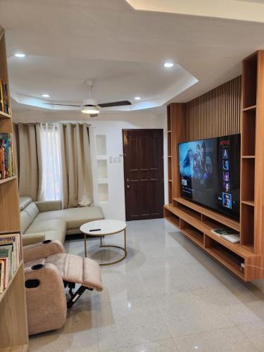 a living room with a couch and a flat screen tv at Riverduplex - Luxury duplex at a fair price in Dauis