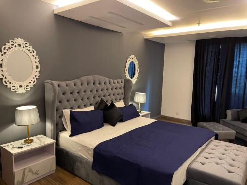 um quarto com uma cama grande e um sofá em Gold Crest Executive Signature Luxury Apartments DHA Phase 4 Lahore by LMY em Lahore