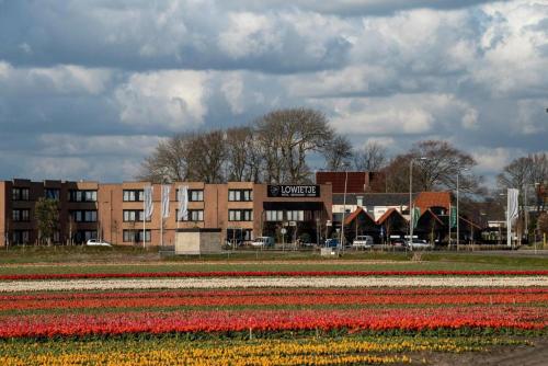 ein Tulpenfeld vor einem Gebäude in der Unterkunft Hotel Lowietje Lisse - Keukenhof in Lisse