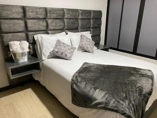 a bedroom with a large bed with two pillows at Beauté in Pereira