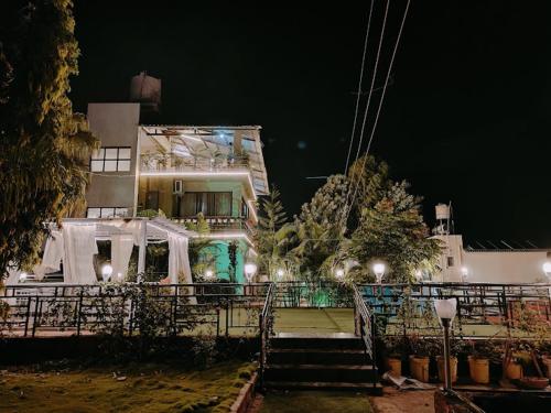 un gran edificio con escaleras que conducen a él por la noche en Strawberry County, en Panchgani