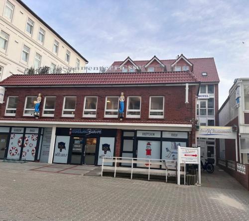 un gran edificio de ladrillo en una calle de la ciudad en Hotel Villa Weststrand, en Borkum