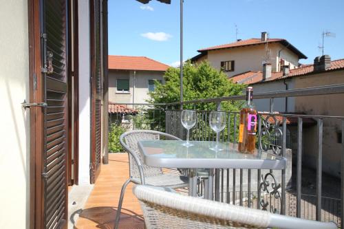 einen Tisch mit Weingläsern und eine Flasche auf dem Balkon in der Unterkunft Sunset in Baveno - Happy Rentals in Baveno