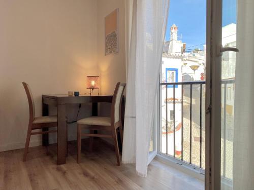 una sala da pranzo con tavolo e sedie e un balcone di Charming 1BR in Lagos Old Town - Near Beach & Cafés a Lagos