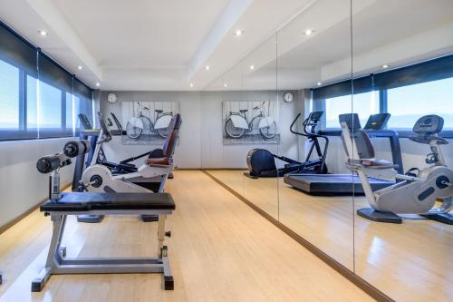 een fitnessruimte met loopbanden en crosstrainers in een kamer bij AC Hotel Vicenza by Marriott in Vicenza