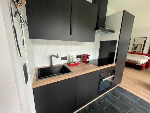 a kitchen with black cabinets and a sink at Flat vane & Soun in Waterloo