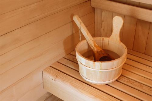 a wooden spoon in a bucket in a sauna at Suite & SPA à La Ferme 1802 in Sainghin-en-Mélantois