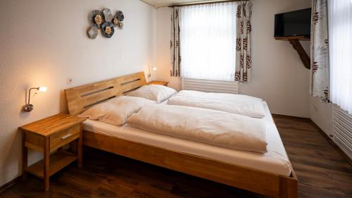 een slaapkamer met een groot bed met witte lakens bij Hotel Royal in Monschau