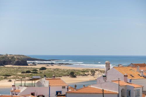 vista su una spiaggia con edifici e sull'oceano di MUTE Hostel Milfontes a Vila Nova de Milfontes