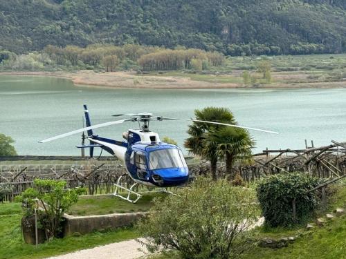 a blue and white helicopter flying over a lake at Arzenhof, Baron Di Pauli in Caldaro