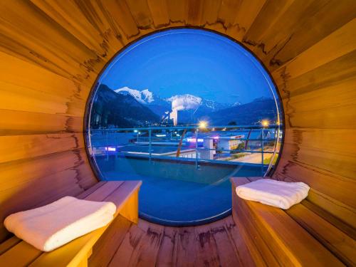 a round window in a wooden room with a view at Ibis Styles Sallanches Pays du Mont-Blanc in Sallanches