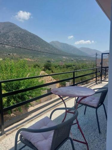 a table and two chairs on a balcony with a view at ΛΕΥΚΙΑΣ. in Pirgos Dhirou