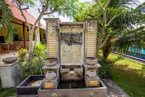 einen Brunnen vor einem Haus mit Bäumen in der Unterkunft The Parnas in Nusa Lembongan