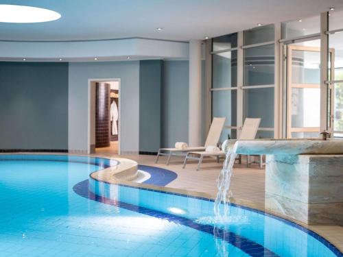 uma piscina com cascata num quarto de hotel em Pullman Stuttgart Fontana em Estugarda