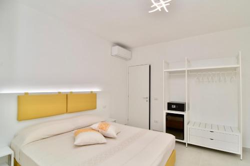 1 dormitorio blanco con 1 cama grande y 2 almohadas en Le Isole di San Teo, en San Teodoro