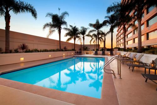 einen Swimmingpool in einem Hotel mit Palmen in der Unterkunft The Westin Los Angeles Airport in Los Angeles