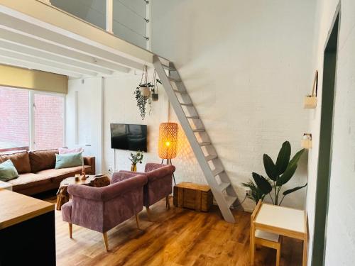 a living room with a couch and a staircase at Bos Water Huisje Veluwemeer in Biddinghuizen