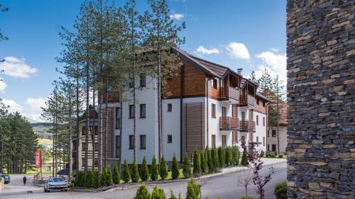 a large white building with wooden shuttering at Hotel Mons in Zlatibor