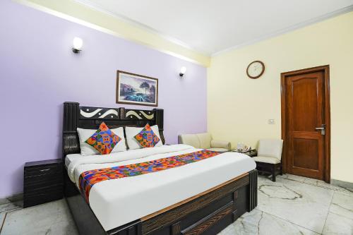 una camera con un grande letto e una porta in legno di FabExpress IVY Inn Sector 35 a Noida