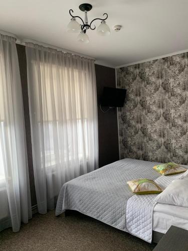 sypialnia z łóżkiem i żyrandolem w obiekcie Yurus Hostel w Lwowie