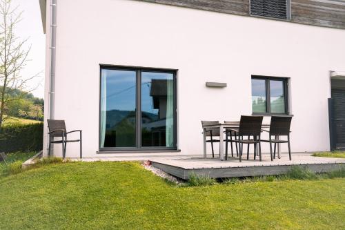 une terrasse avec des chaises et une table en face d'une maison dans l'établissement Apartments Verde, à Grein