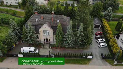 a house with cars parked in a parking lot at Dworek pod świerkami in Jelenia Góra