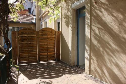 een paar houten poorten voor een gebouw bij La terrasse du JULES in Romans-sur-Isère